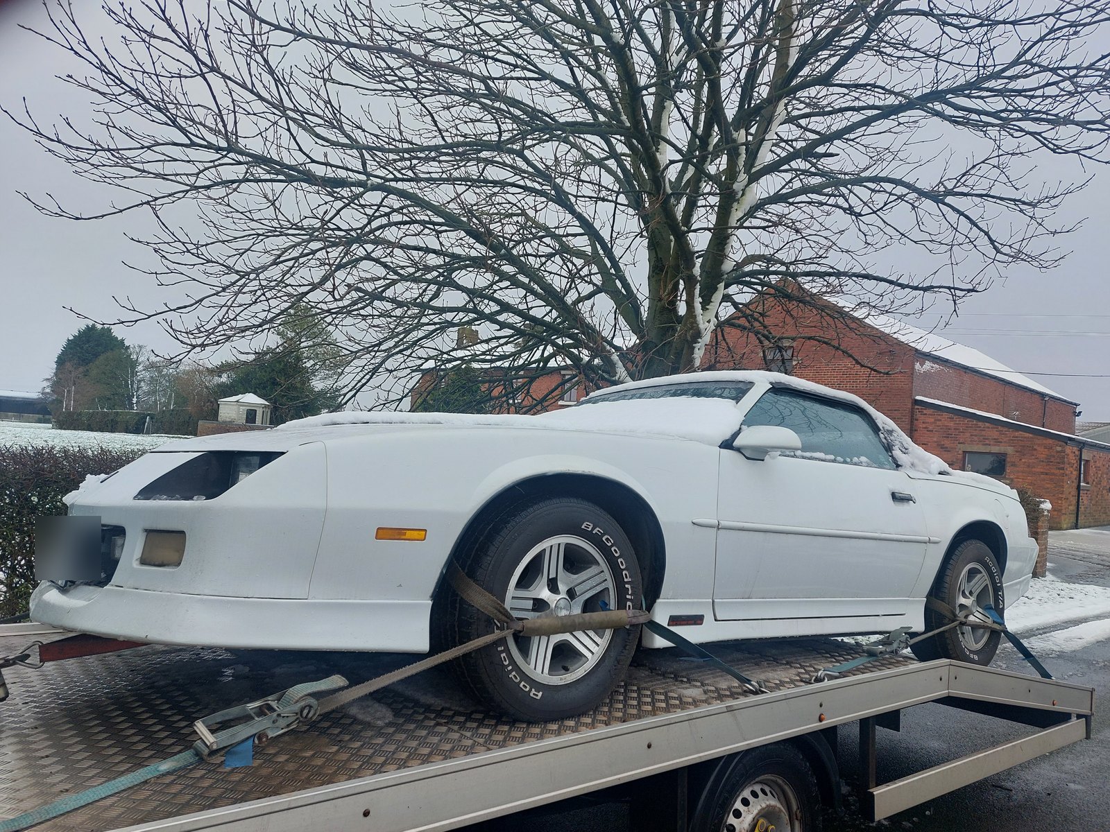 Non-running Chevrolet Camaro winched onto the WS Logistics truck in the snow