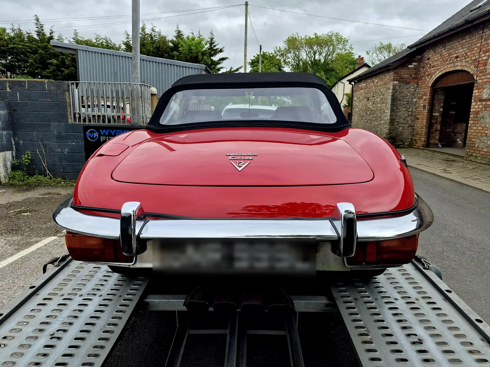 Rear view of a classic Jaguar E-Type secured on an open transporter between Garstang and Hambleton