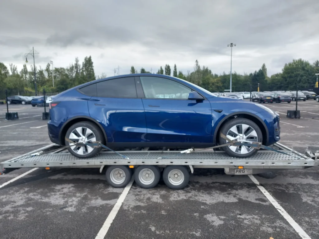Blue Tesla Model Y transported by WS Logistics, electric vehicle delivery