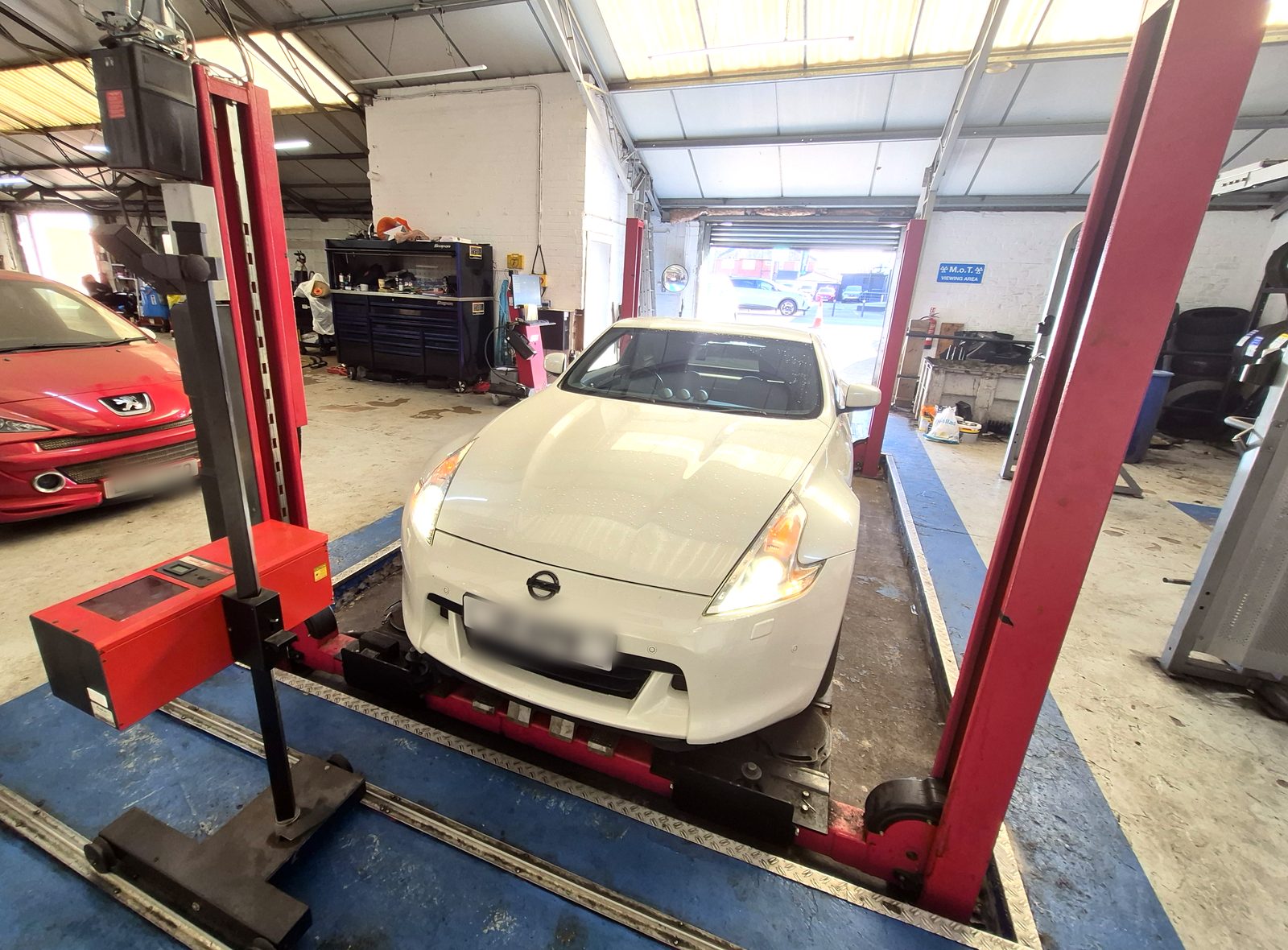Headlamp beam tester in position at the front of a car during an MOT test, the kind of test watched right through during a quality control check
