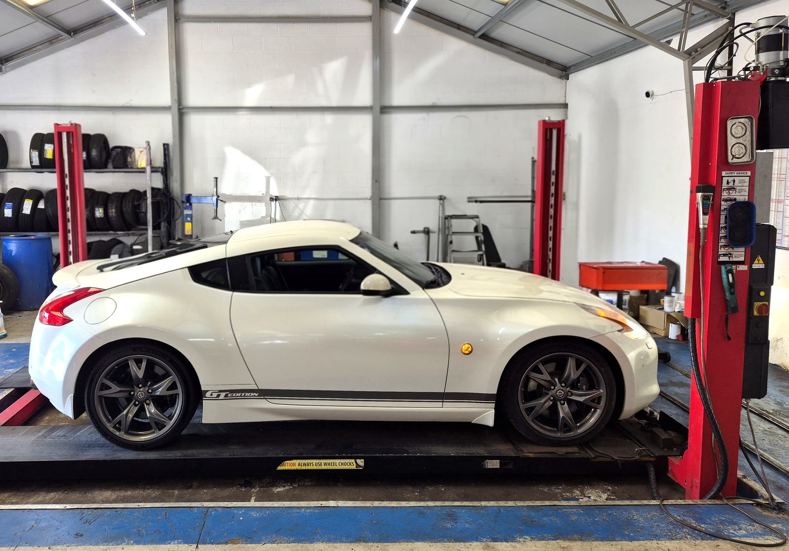 A car on the ramp in a garage MOT bay, the setting for an independent MOT quality control check by WS MOT Services