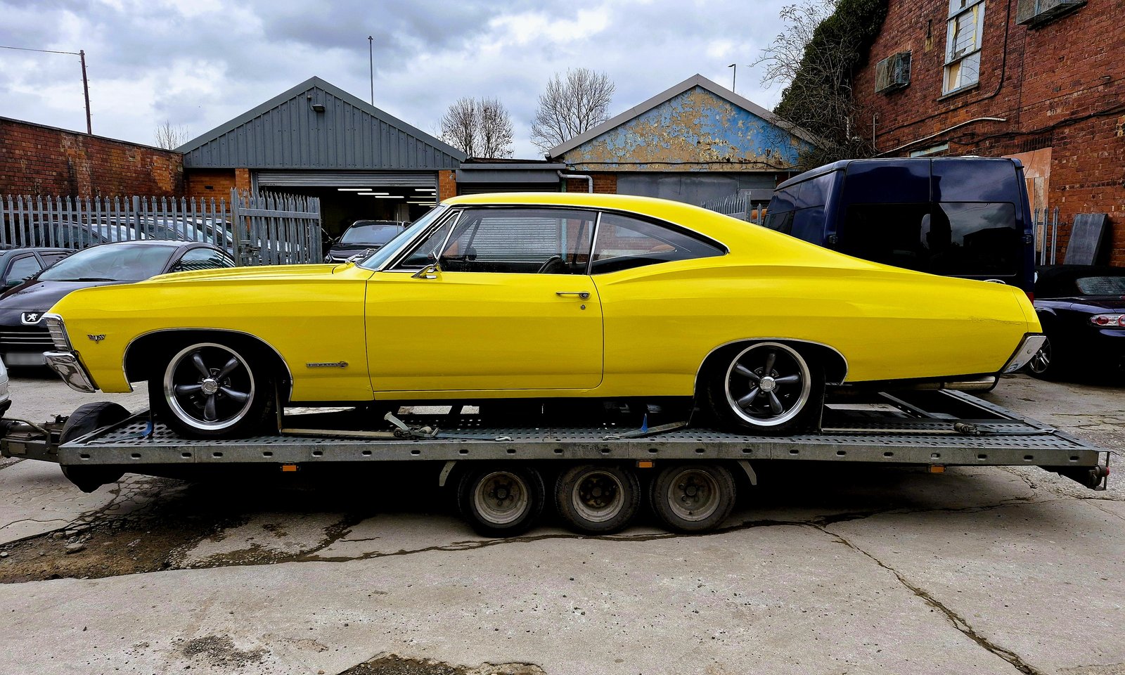 1967 Chevrolet Impala side profile strapped on the WS Logistics open trailer