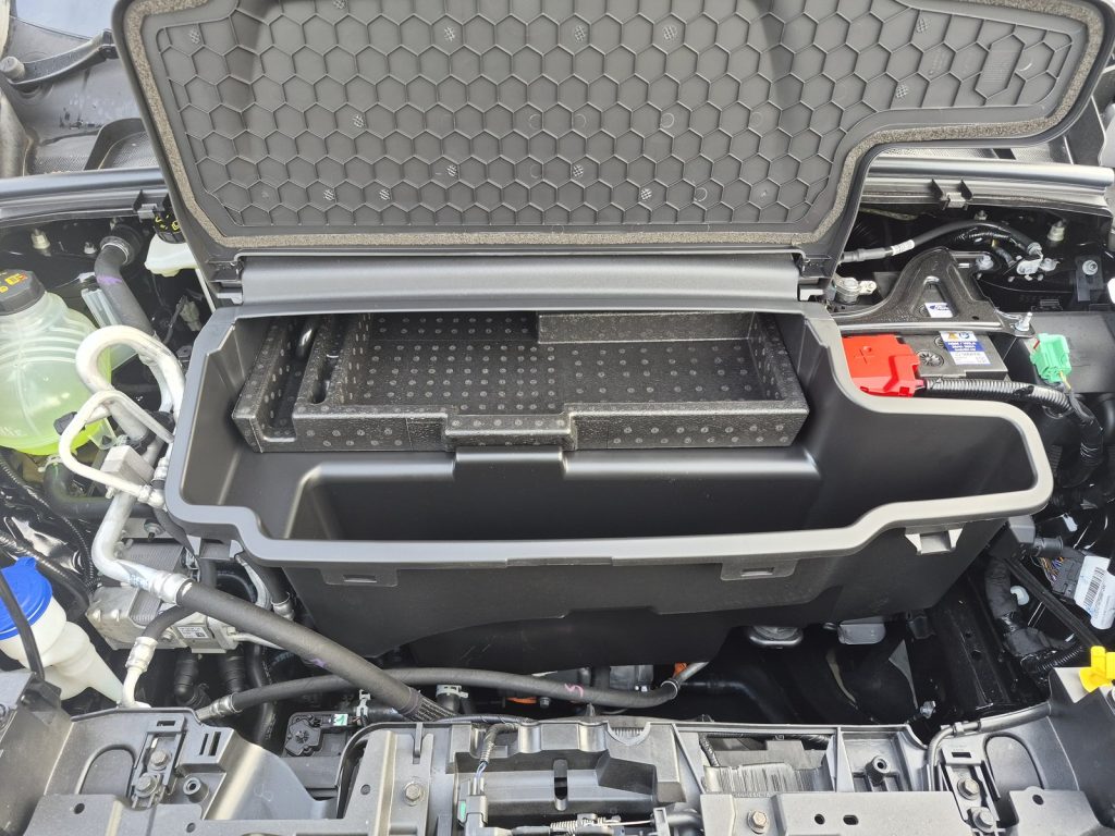 Front storage compartment open on an electric Ford Puma Gen-E, with the electric motor mounted underneath