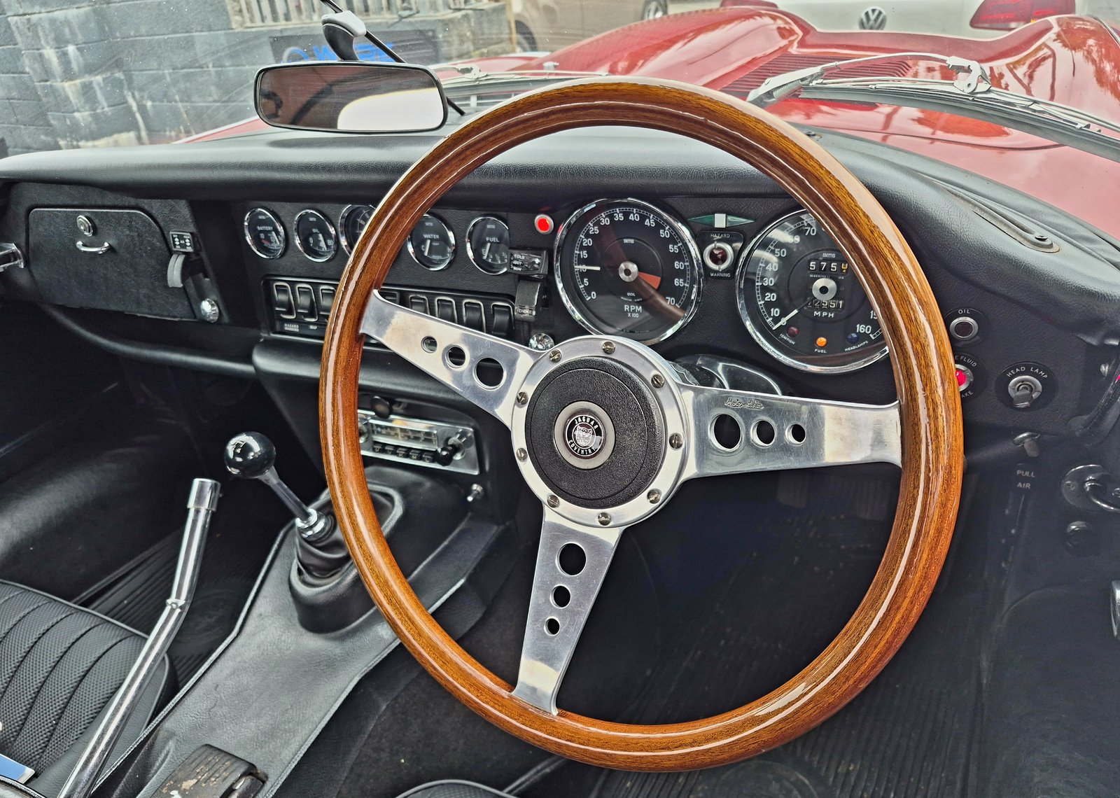 Jaguar E-Type interior with its wood-rim steering wheel and original dials